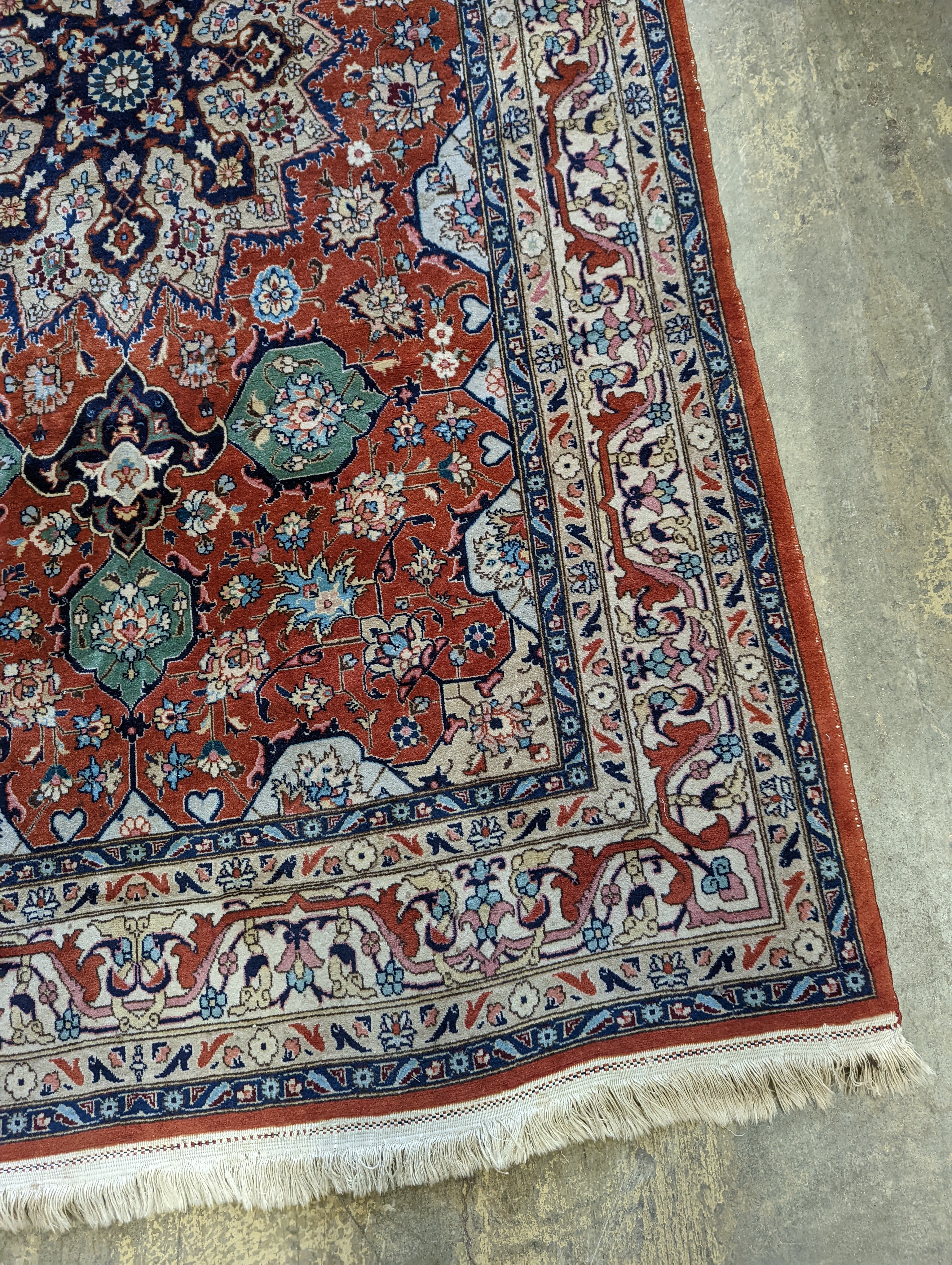 A Tabriz brick red ground rug, 230 x 138cm